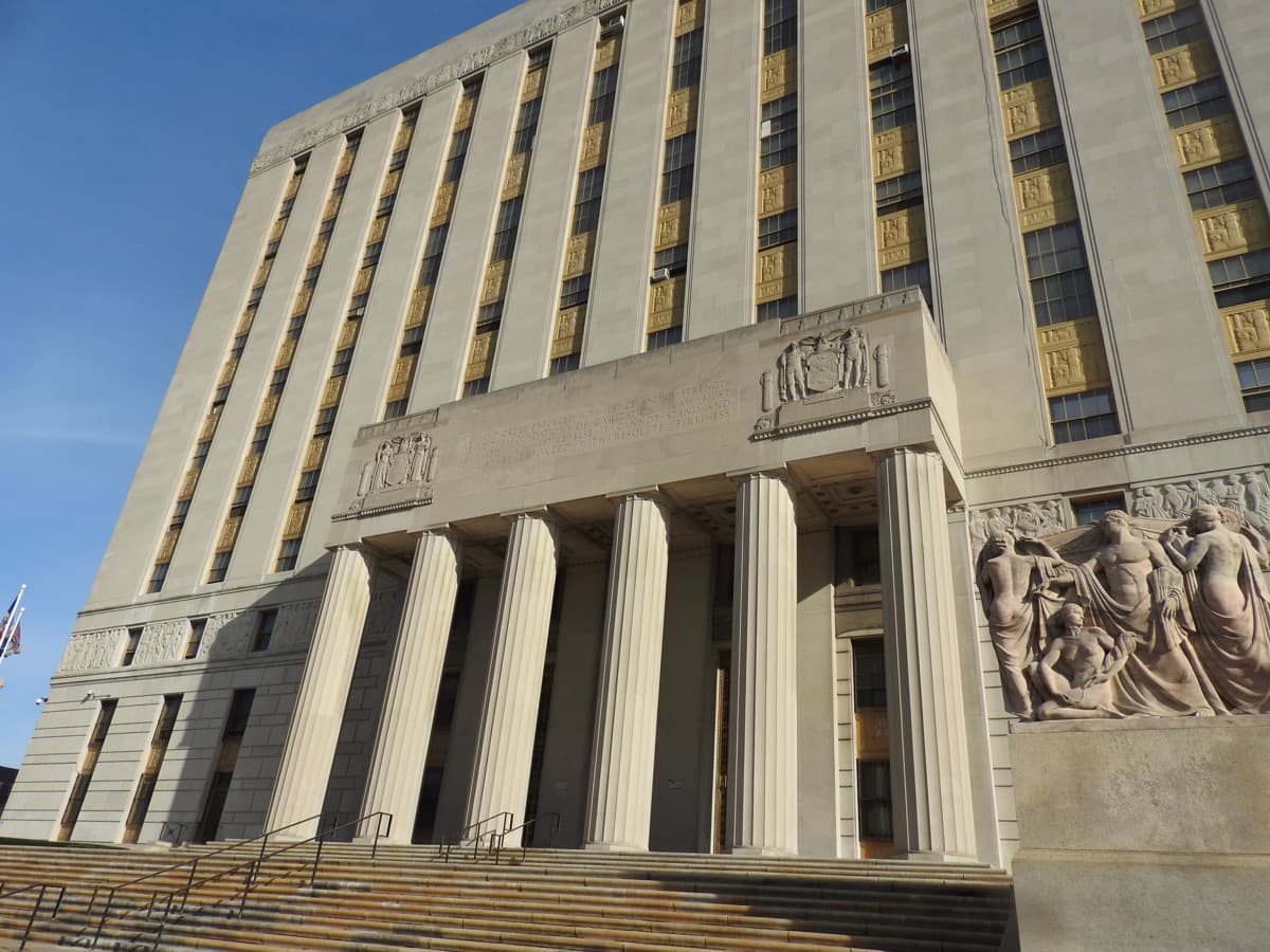Low-angle view of the Bronx County Courthouse entrance with carved friezes and columns